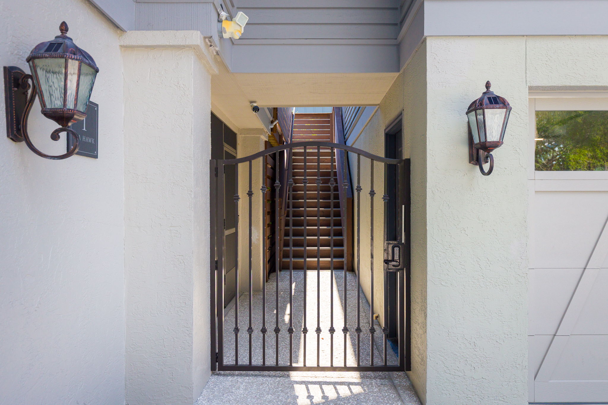 Gated secure entryway with keypad gate; stairs lead to the pool.