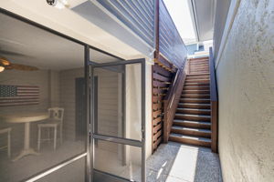 Screened in porch leads to the front door; stairs to the pool.