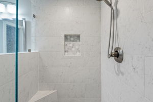 Large walk-in shower in the Primary Bath w/ seating & niche for toiletries.