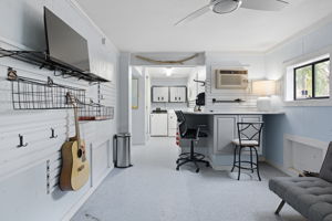 A Man Cave underneath the house has a workstation, seating and room for tools.
