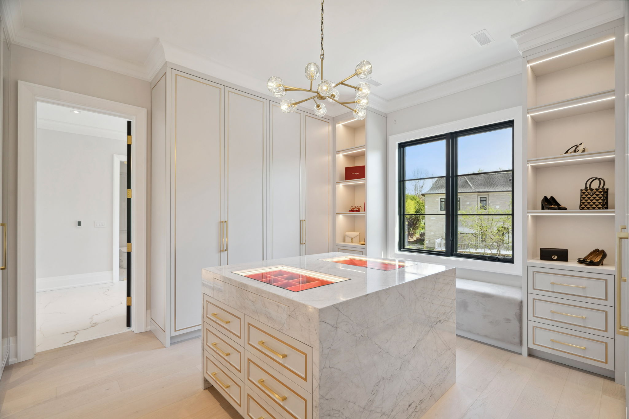 Luxurious walk-in closet with central marble island at 1 Sunflower Court, design by Rafael Gomes. Photo by amazingphotovideo.com, site by cranemedia.com