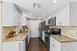 Kitchen features double stainless steel sink, granite counters, and soft-close cabinetry.