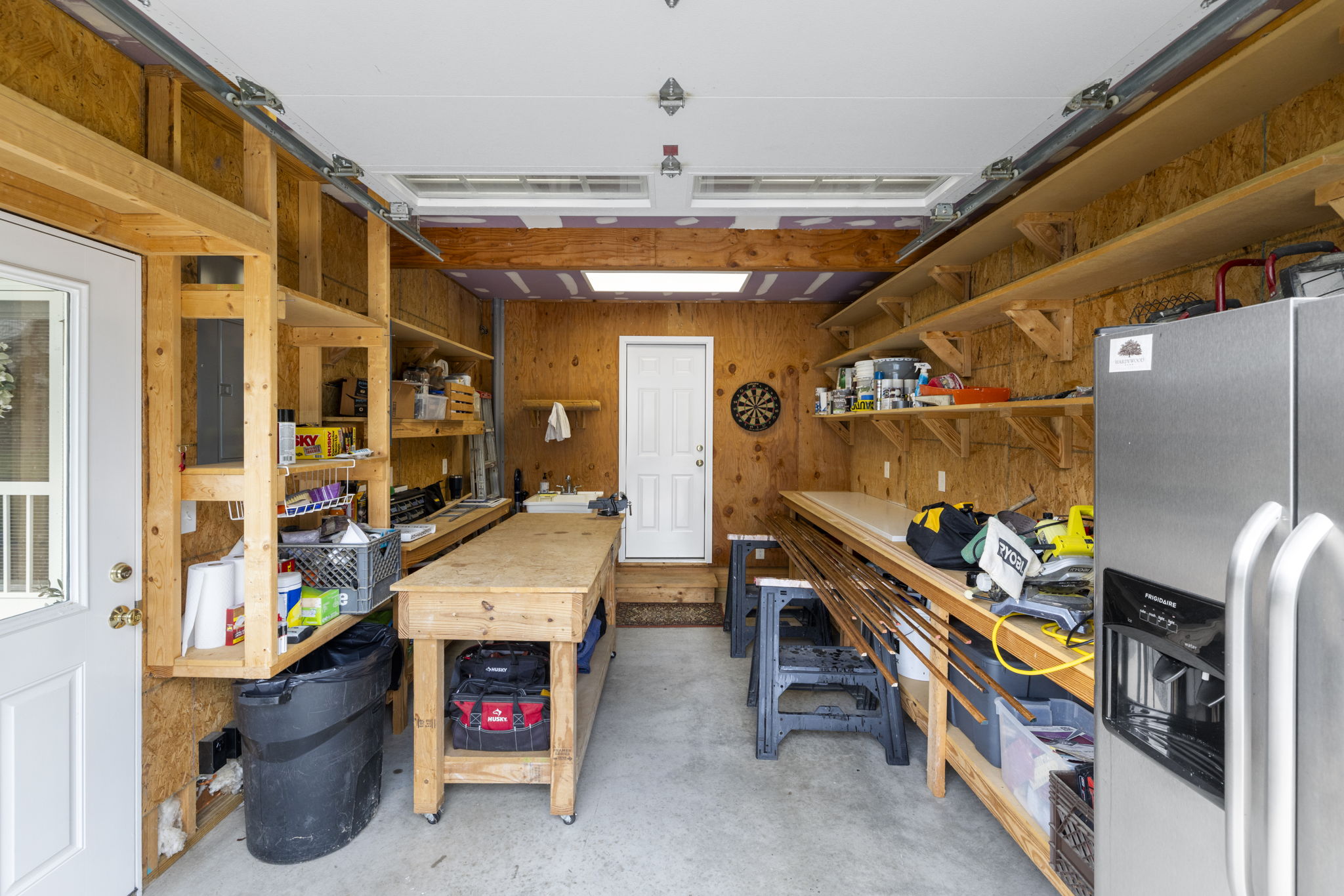 Garage currently set up as a workshop with polished concrete floor and custom built shelving provides excellent storage and organization solutions.
