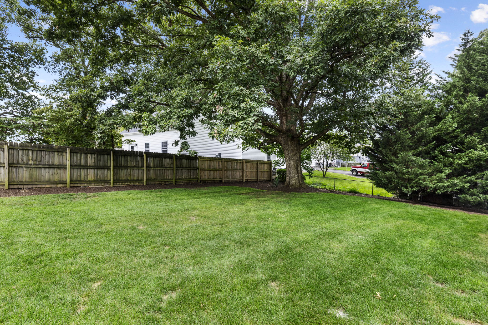 Expansive lawn with a beautiful white oak tree providing plenty of shade.