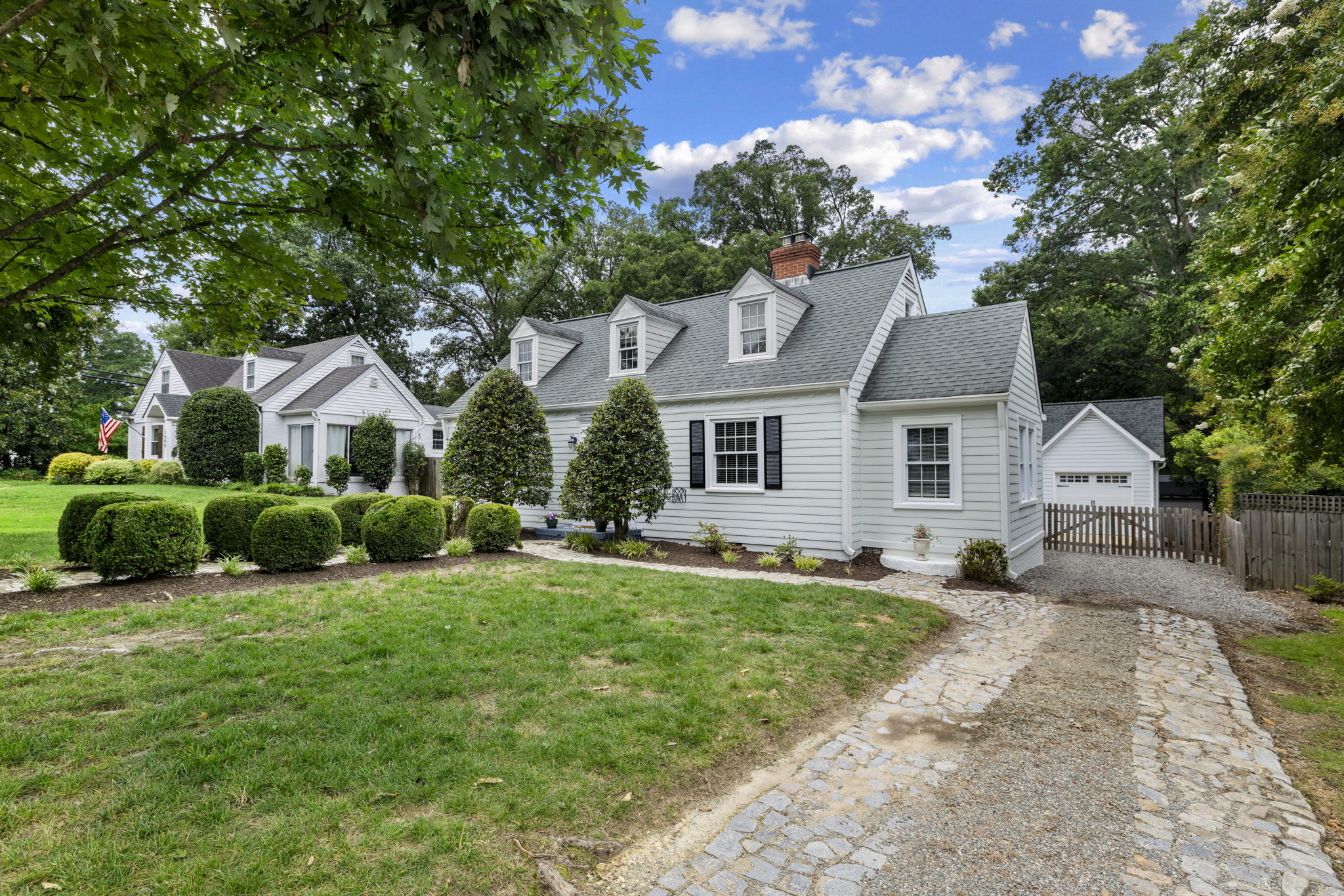 Coblestone driveway & walk way lined with boxwoods enhance the curb appeal and give excellent off-street parking space.