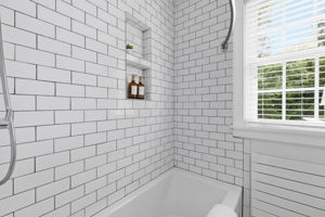 White subway tile surround, built-in shower niche, and a white tall soaking Kohler tub round out this beautiful bath renovation.