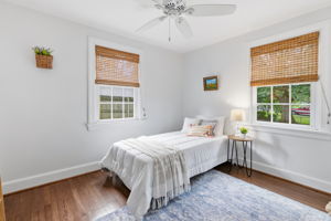 Rear 1st floor bedroom has beautifully refinished hardwood floors, a nice closet and white Hunter ceiling fan.