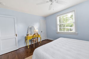 Hardwood flooring, painted walls, two-panel interior doors, and a ceiling fan.