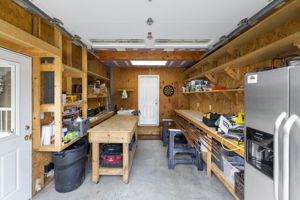 Garage currently set up as a workshop with polished concrete floor and custom built shelving provides excellent storage and organization solutions.