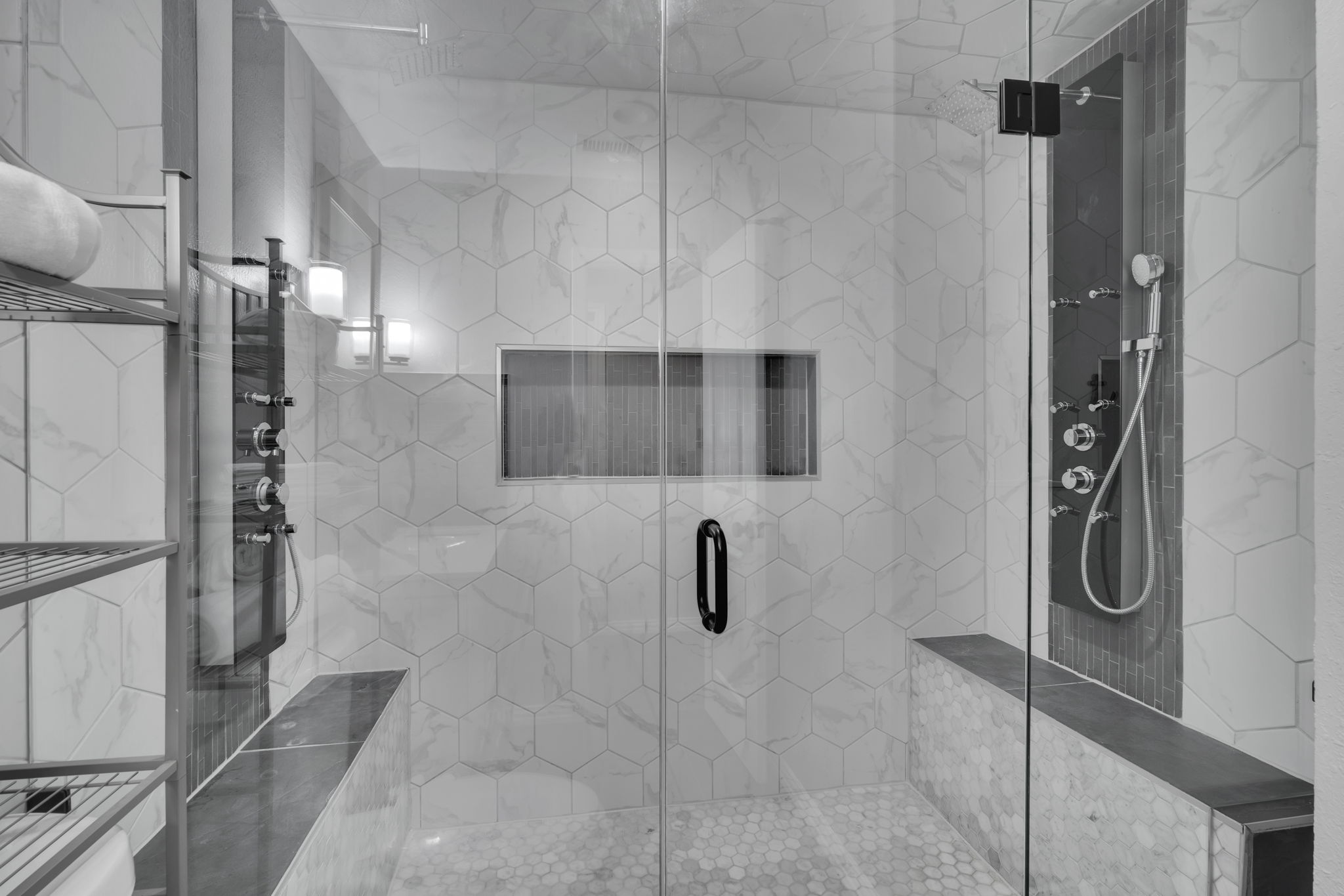 Bathroom features an enclosed double shower along with spa benches