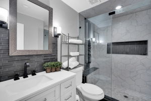 Beautifully renovated bathroom with vanity, tile walls and a huge shower
