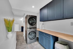 Stacking washer/dryer allows for extensive storage and counter space
