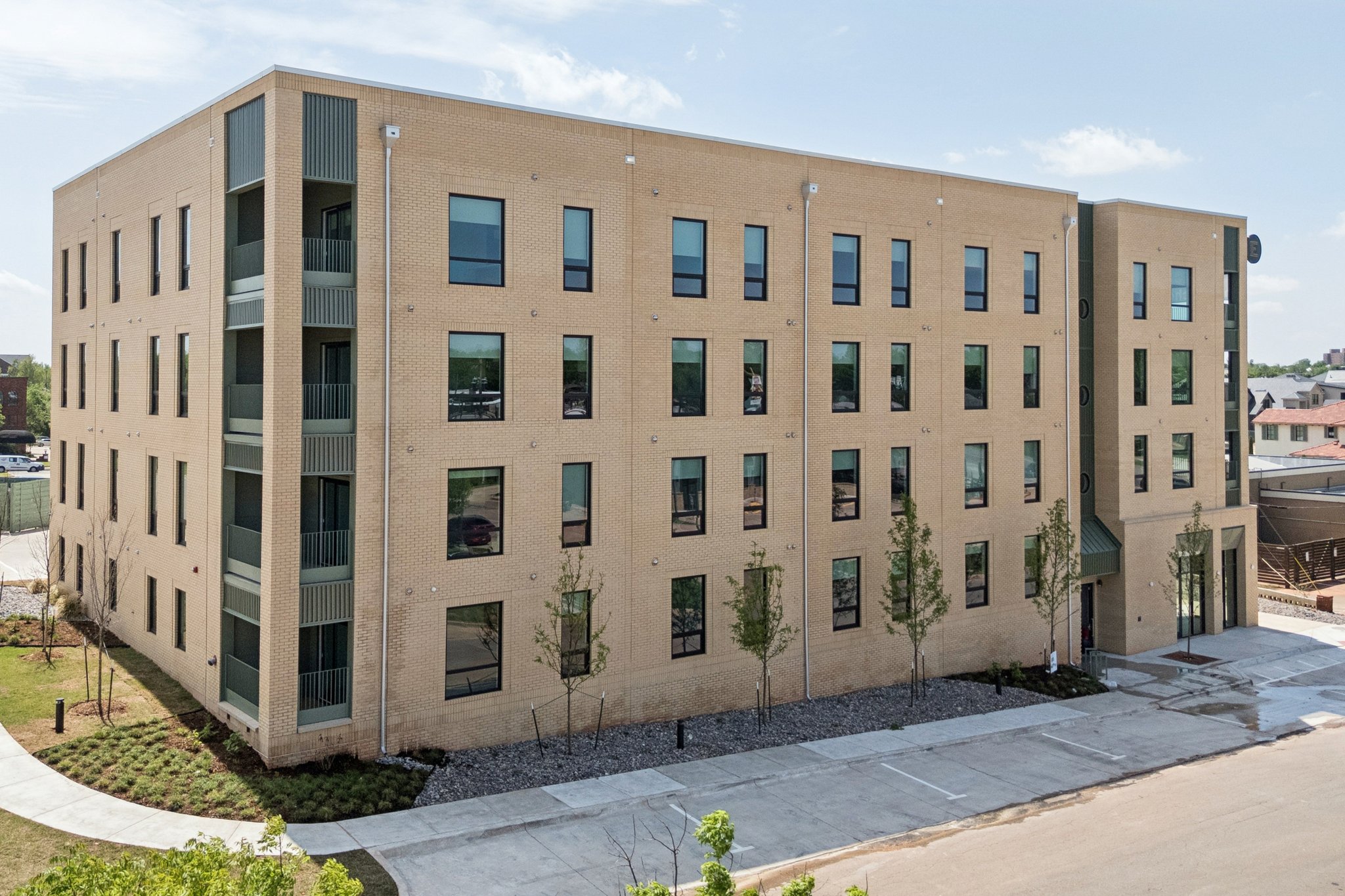 Four-story apartment building with a covered entry and new street trees