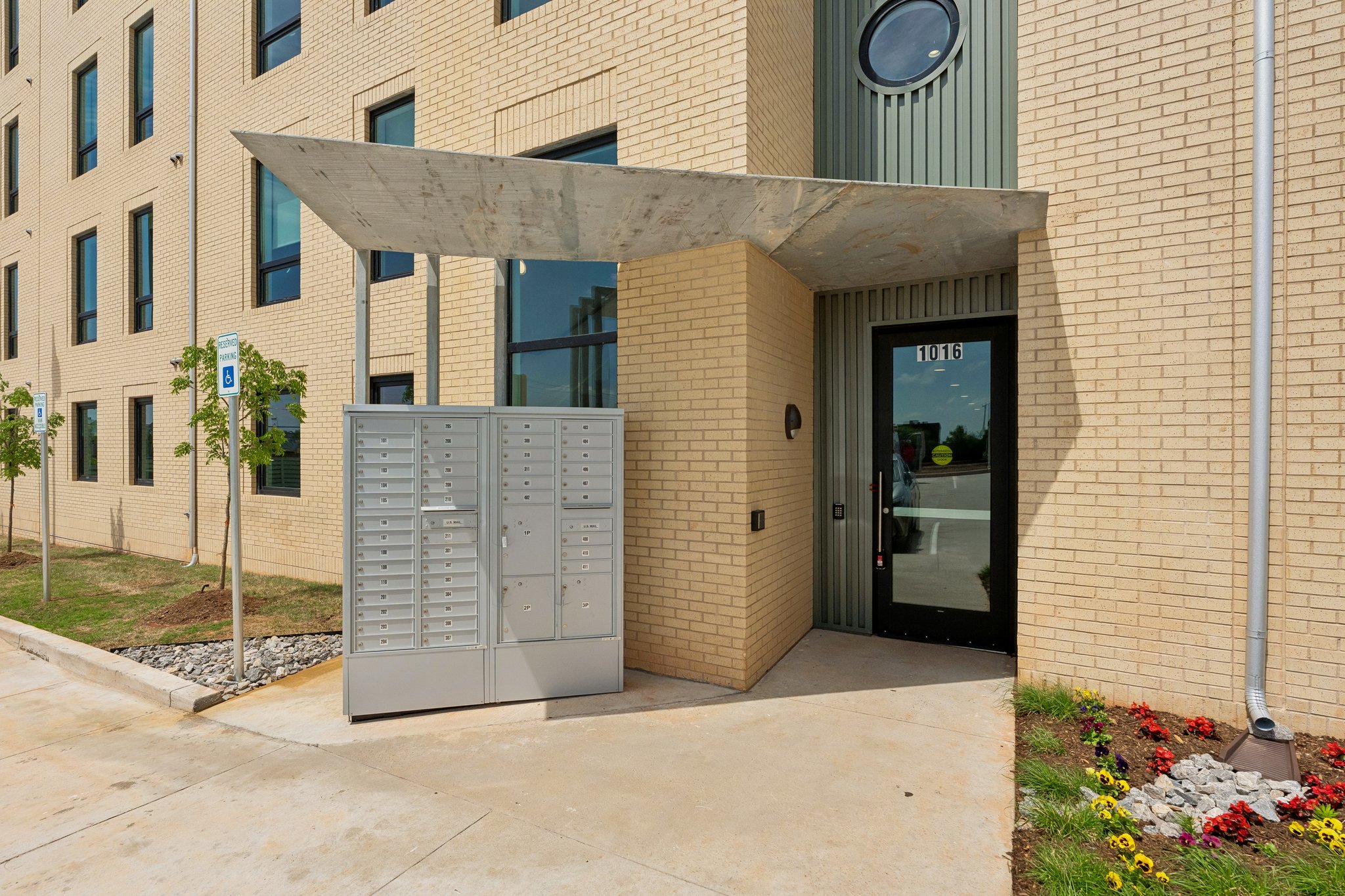 Covered resident entry with package lockers beside the door