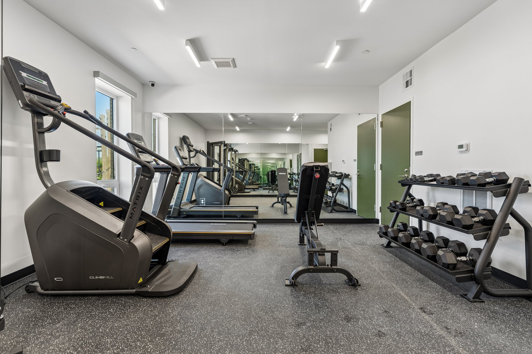 Community fitness center with cardio machines and a dumbbell rack