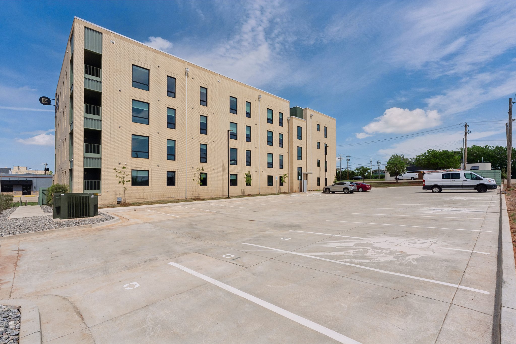Apartment building and resident parking under a blue sky