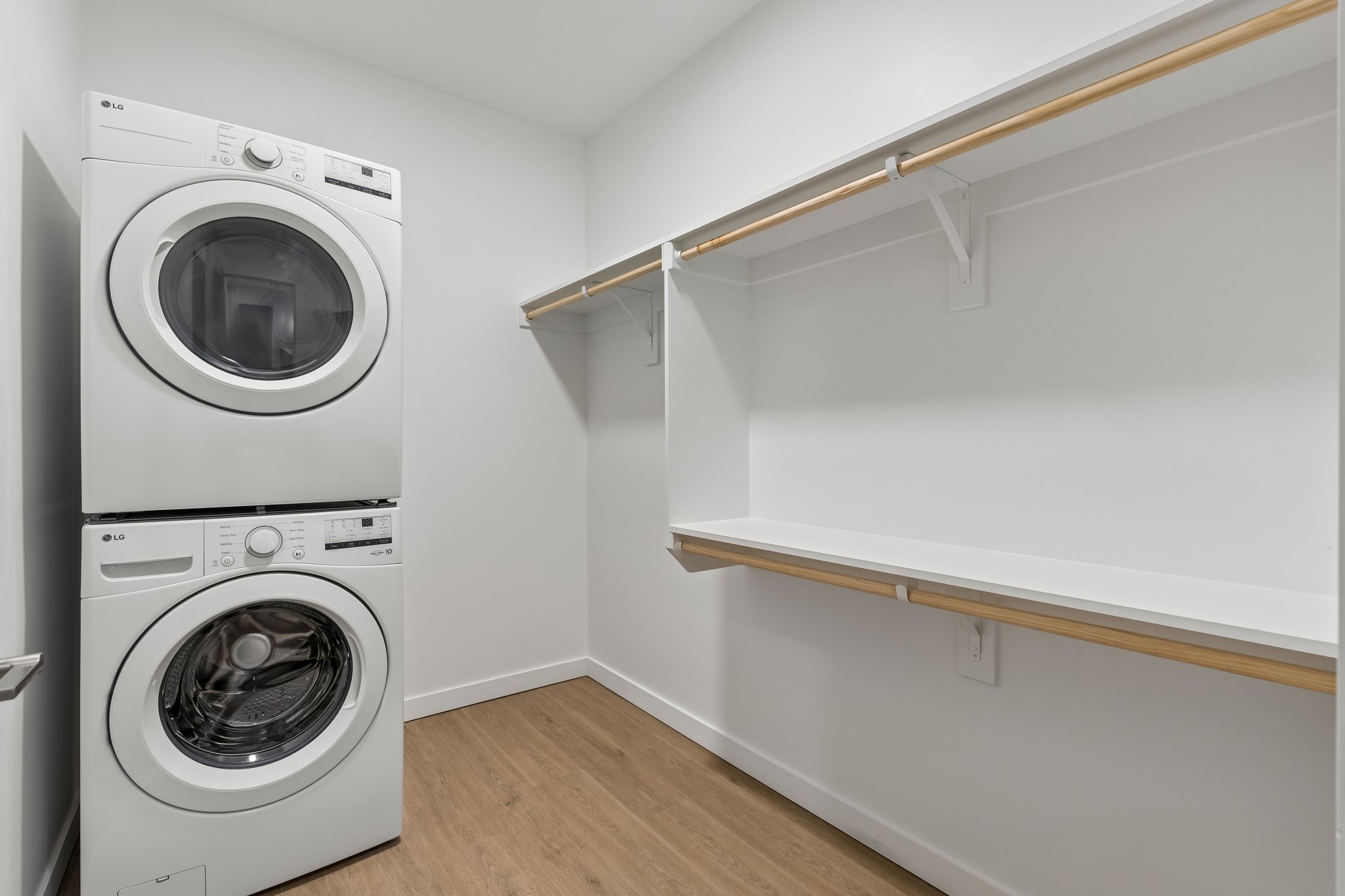 In-unit stacked washer and dryer beside a walk-in closet