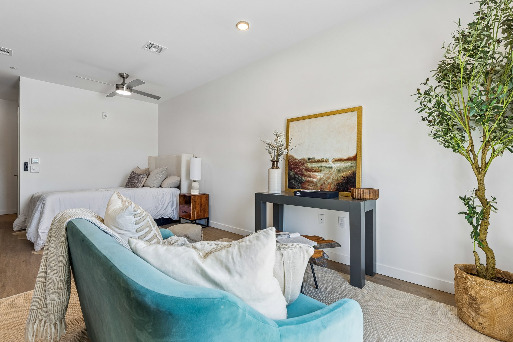 Second floor plan living room with a teal sofa and a window over the city
