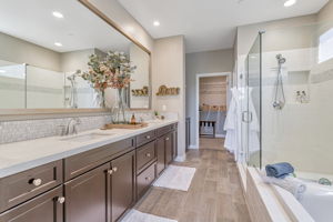 Primary suite bathroom with dual sinks, tub and shower.