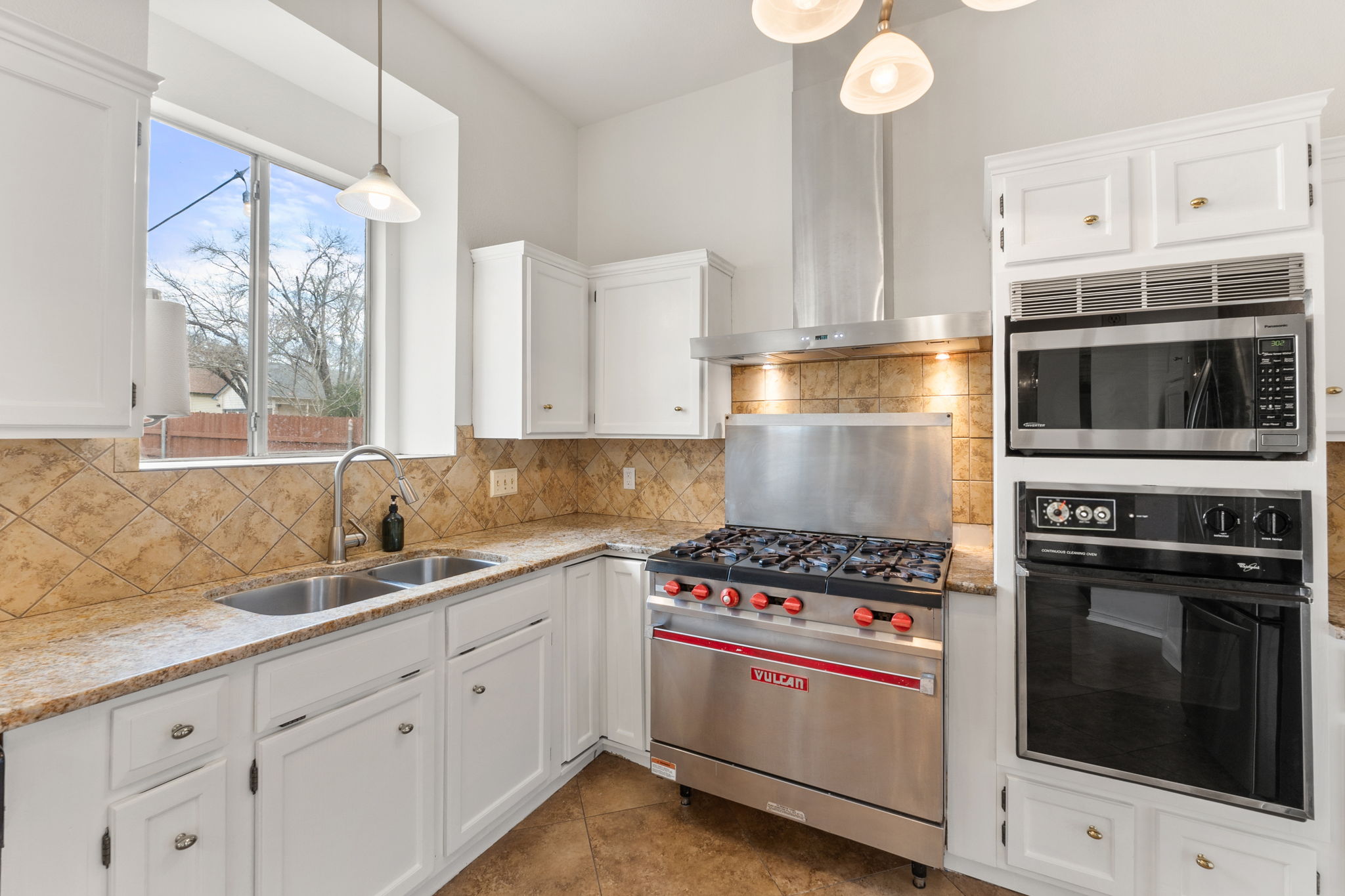 Recently painted cabinets and walls, the white kitchen is homey and inviting.