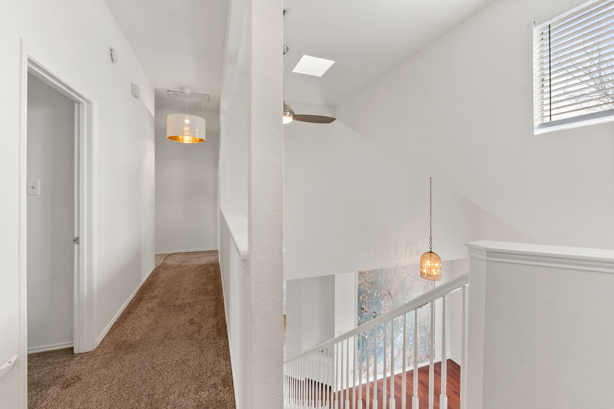 An almost straight-on view from the stairwell landing onto the hallway leading to the bedrooms.