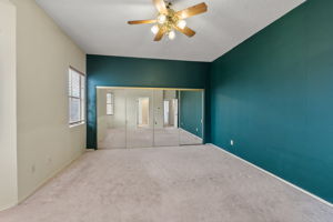 Neutral colored carpet, and off white walls, along with the green walls sets this primary bedrooms apart from most boring rooms.