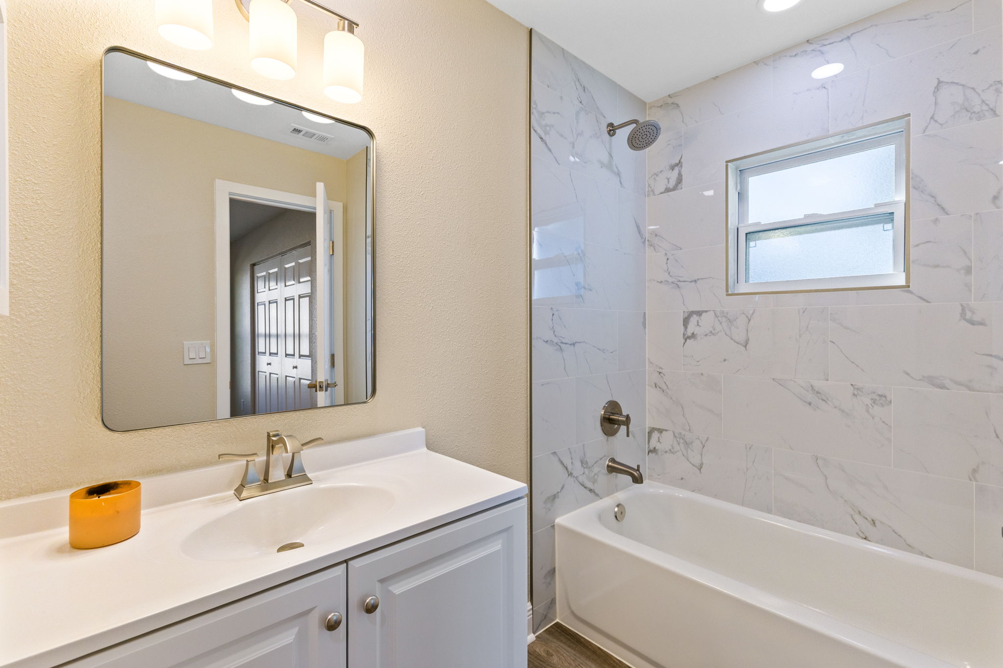 Renovated bathroom featuring ceiling-height tile and modern finishes.