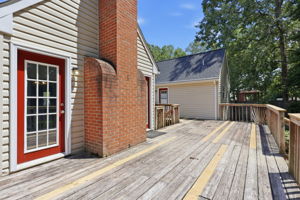Deck with two entrances to sunroom and primary bedroom