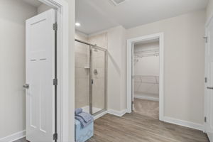 Separated water closet by a tiled walk-in shower