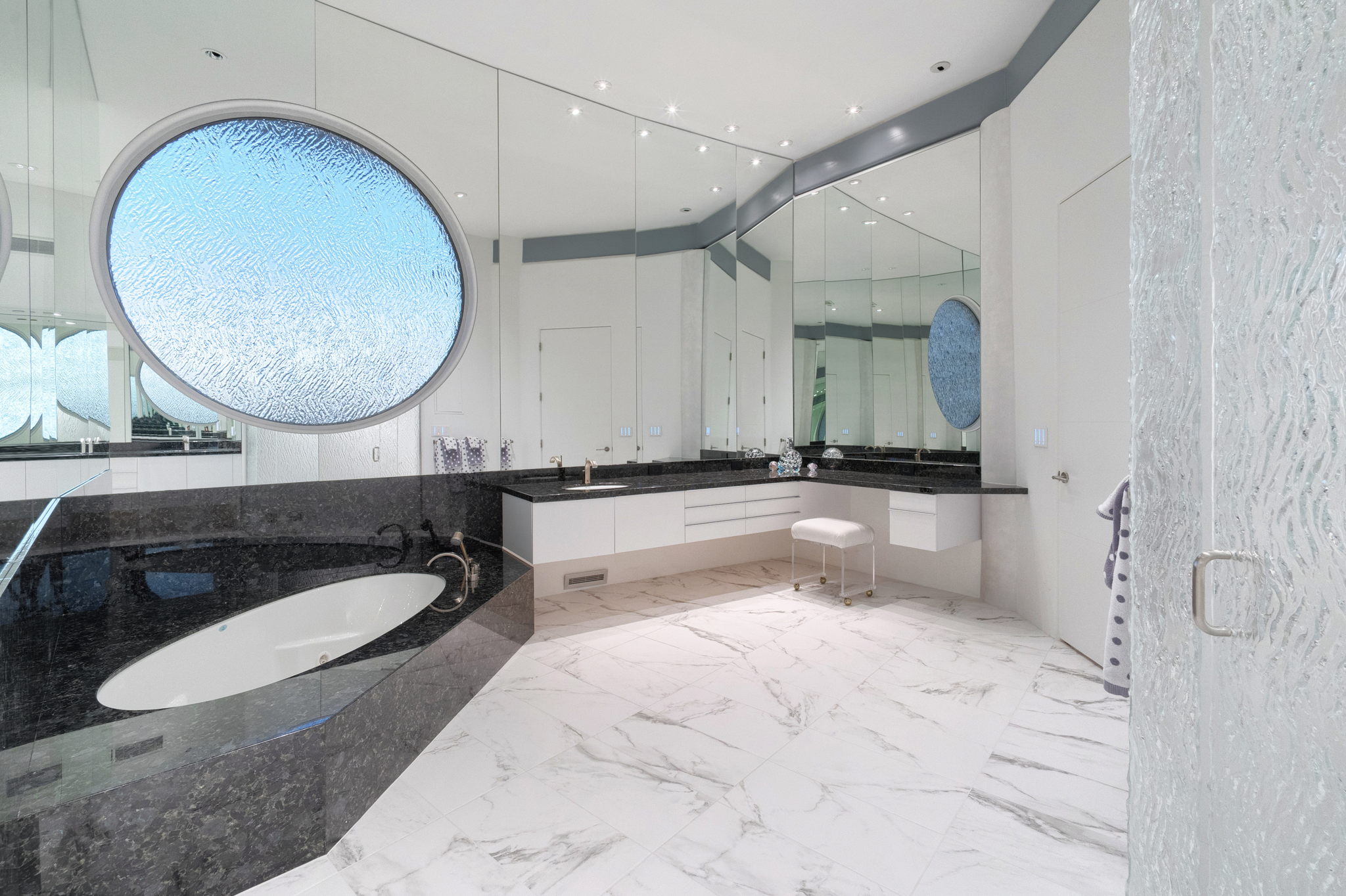 Owner's Suite Bathtub: Round frosted glass window mirrors glass on facing walk in shower