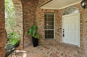 The charming covered entryway offers a welcoming first impression and doubles beautifully as a sitting area.