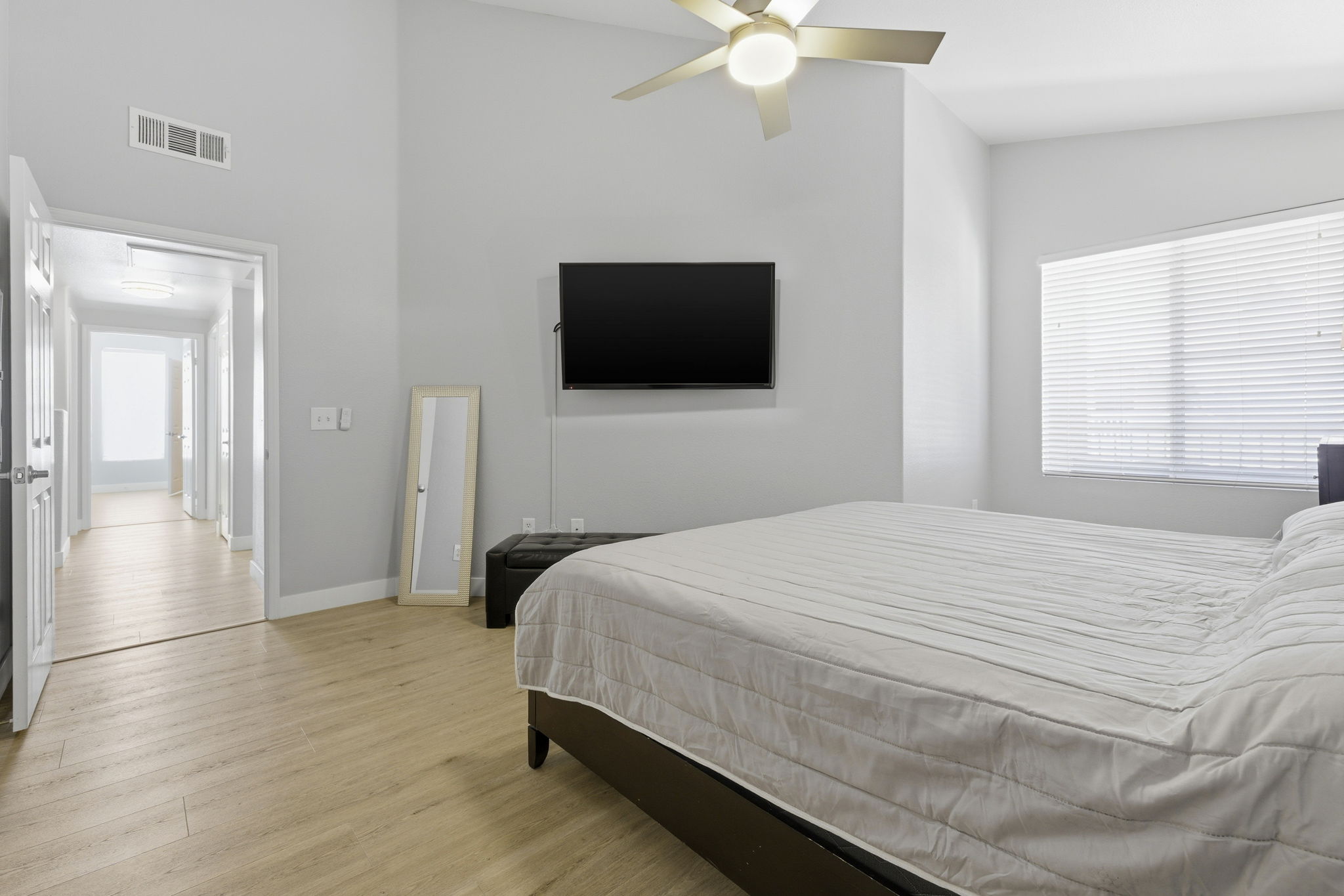 Primary bedroom with vaulted ceiling & natural light.