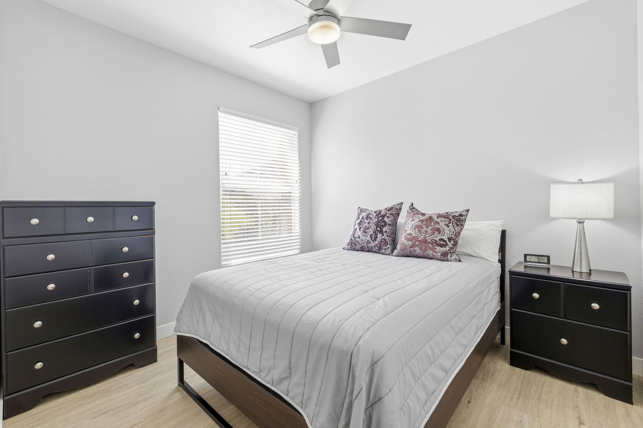 Generous third bedroom with high ceilings and upgraded flooring.