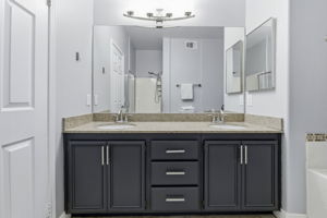 Dual sinks in primary bathroom with custom lighting.