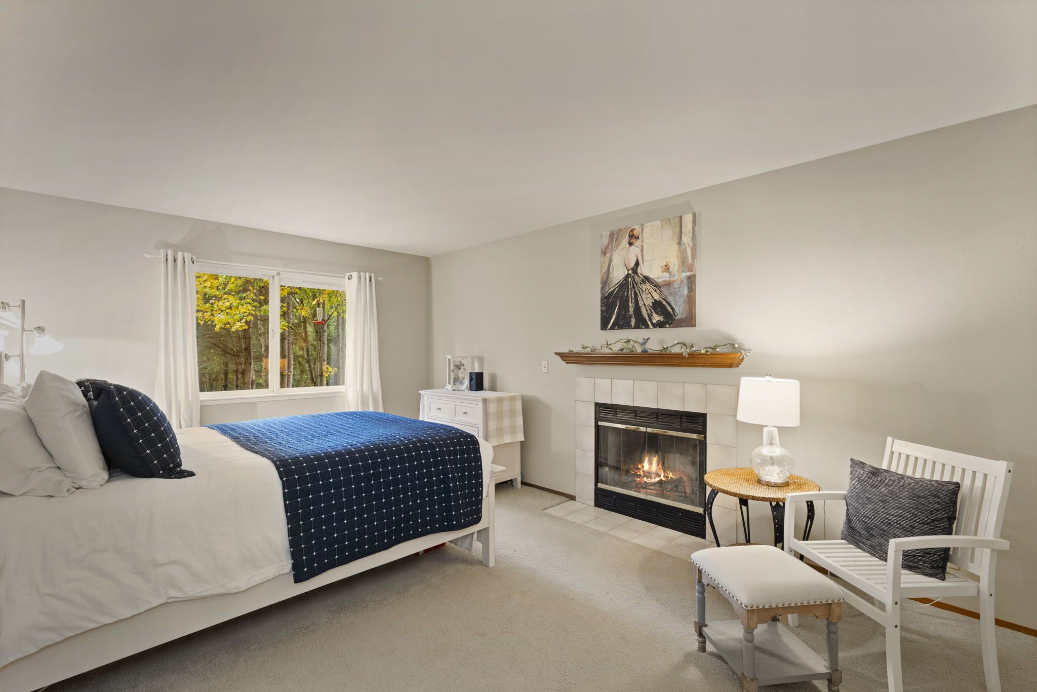Primary bedroom with views to the beautiful, private backyard. Wood burning fireplace.