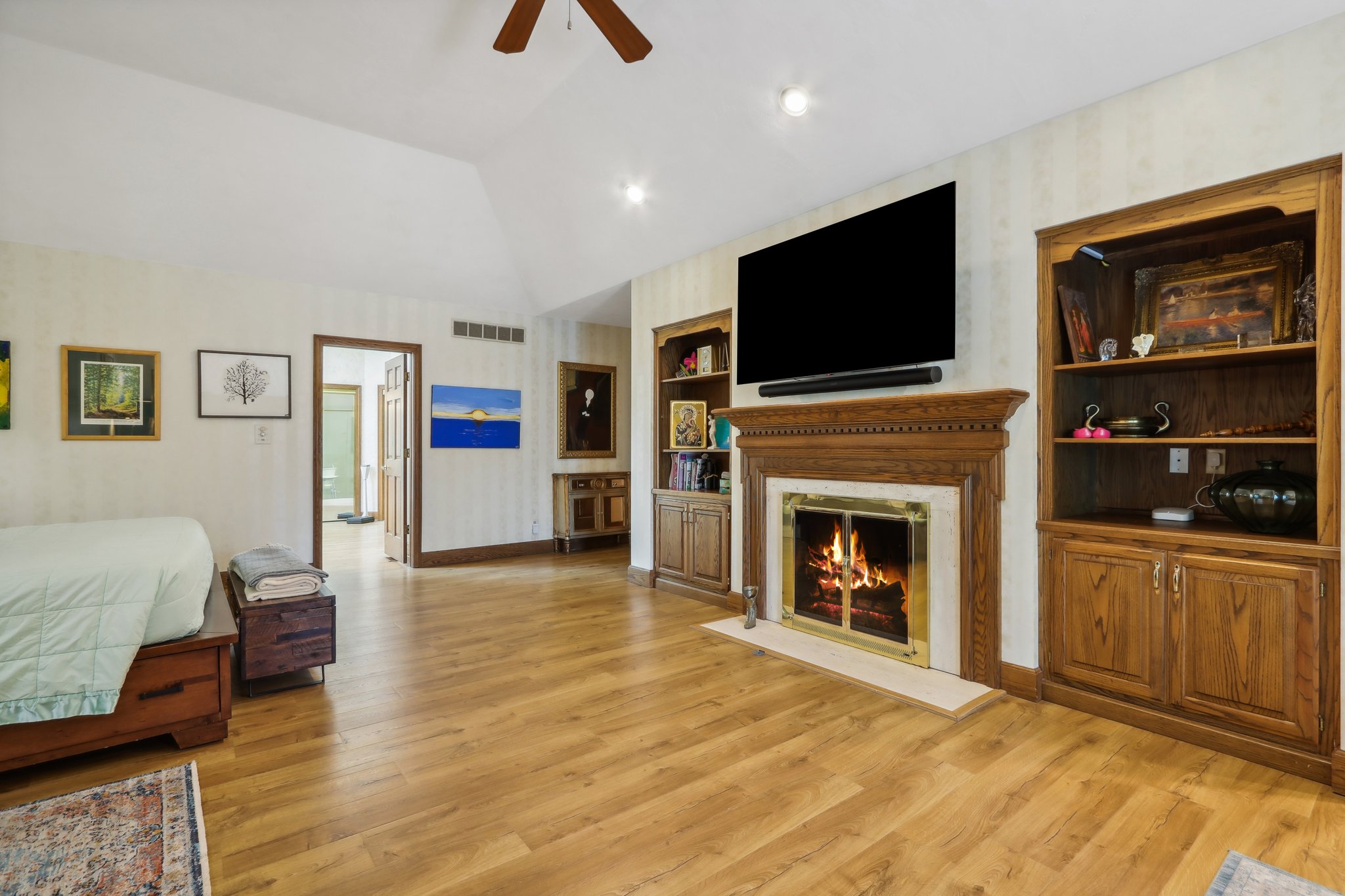 Primary bedroom featuring gas fireplace #3, built-in shelves, a wet bar, and doors to patio
