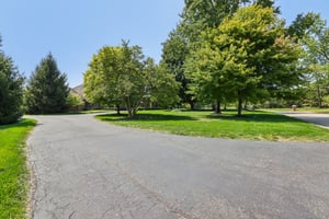 View from far side of driveway, house is on the left, road on the right