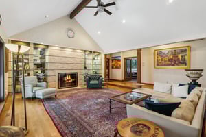 Great room with vaulted ceiling and lighted glass display shelves