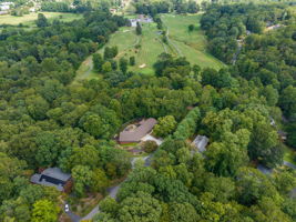 Property Surrounded by Woods and scatered Neighbors with Golf Course in Background View