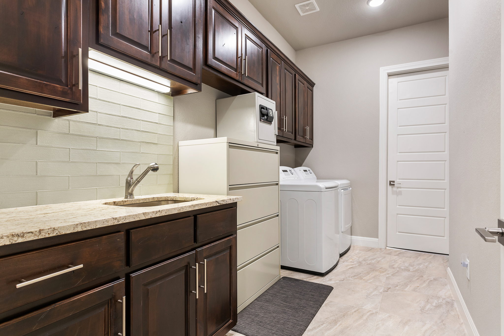 Large utility room with closet, sink with granite countertops and Knotty Alder cabinetry