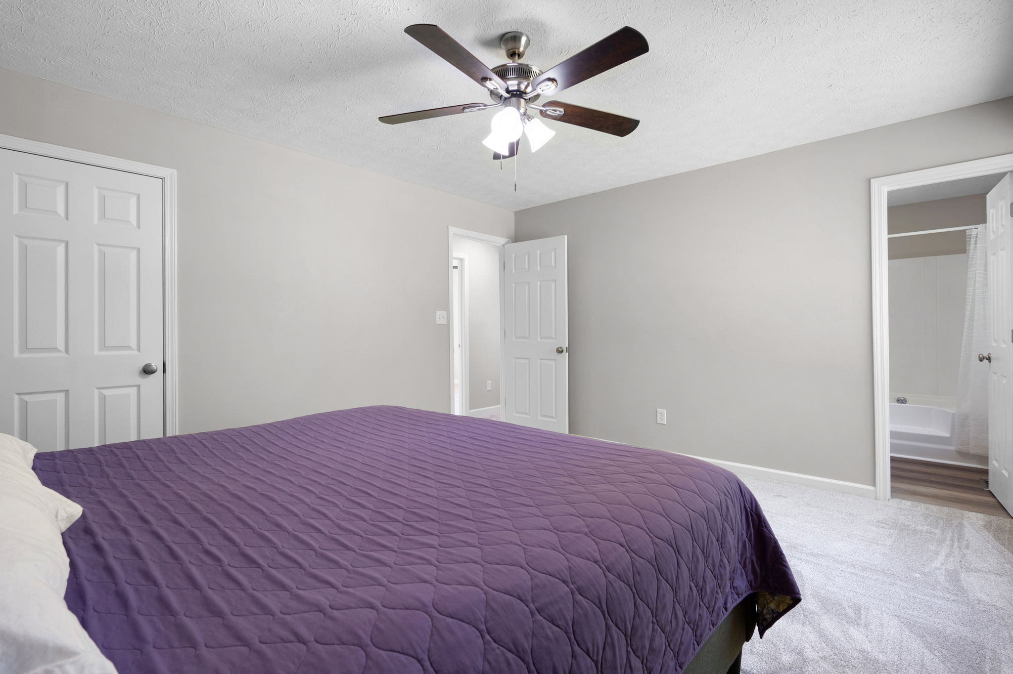 The primary suite features new paint, new carpet and a new ceiling fan.