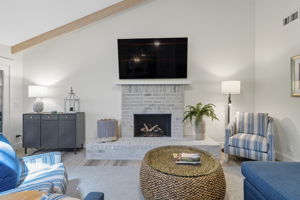 Living area with propane firplace and volume ceilings.