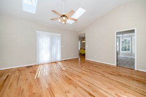 The spacious vaulted Living Room with skylights and ceiling fan, also features . . .