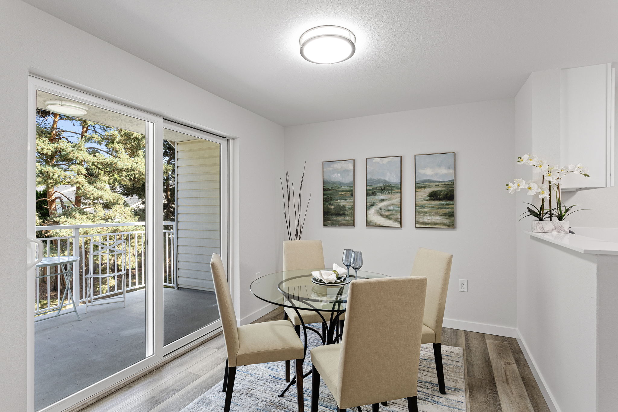 Dining opens directly to the covered balcony, with lawn and mature trees just beyond.