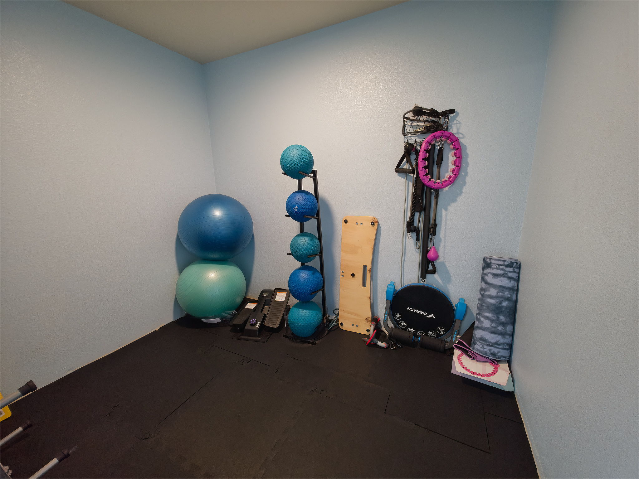 A separate fitness alcove adds space for stretching and floor work, with exercise balls, resistance gear, and mats.