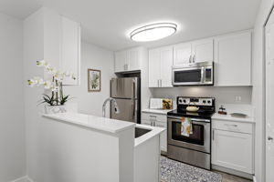 The remodeled kitchen opens to dining through a wide pass-through, keeping the space connected without giving up a defined kitchen.
