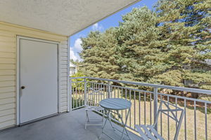 Morning coffee gets the east light here—quiet, elevated, and private-feeling, with lawn and mature trees beyond. Catch up on a good book in the afternoon. The door on the left opens to approx. 25 sq. ft. of dedicated balcony storage.