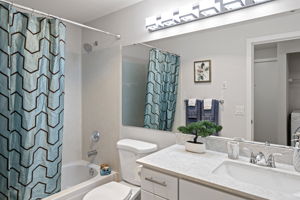 The main bath was substantially updated with a new vanity, quartz countertop, undermount sink, faucet, toilet, lighting, towel hardware, and tub/shower fixtures; only the original tub and surround remain.