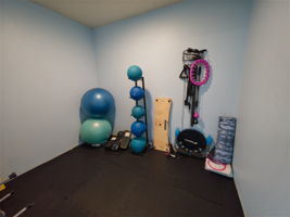 A separate fitness alcove adds space for stretching and floor work, with exercise balls, resistance gear, and mats.