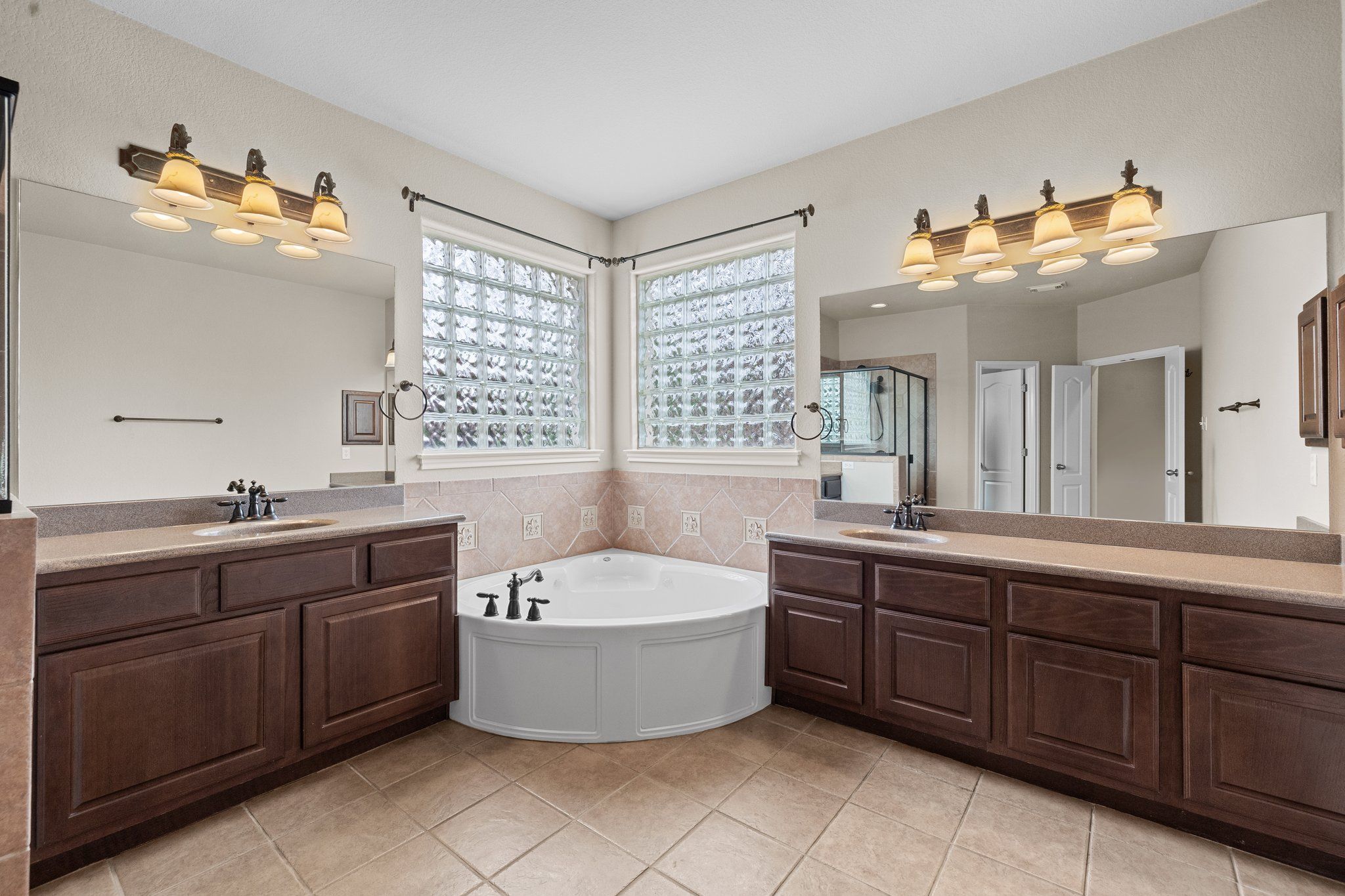 Lovely master bathroom with two sinks, large walk-in shower, jetted tub
